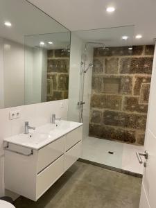 een badkamer met een witte wastafel en een spiegel bij Corazón casco viejo in Vigo +15 foto's