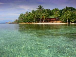 an island with palm trees and a resort in the water at Elba House in Bocas del Toro