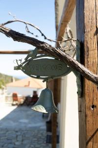 a green bell hanging on the side of a building at Odysseas Pelion House in Kalamaki