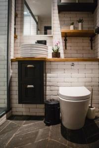 La salle de bains est pourvue de toilettes et d'un comptoir avec des assiettes. dans l'établissement •MangoHausLondon• •airconditioned•garden•fire pit•, à Londres