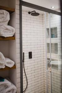 La salle de bains est pourvue d'une douche avec une porte en verre. dans l'établissement •MangoHausLondon• •airconditioned•garden•fire pit•, à Londres