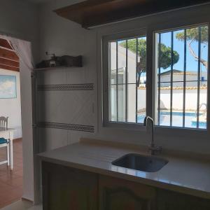 uma cozinha com um lavatório e uma janela em Villa Esperanza em Chiclana de la Frontera