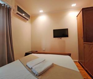 um quarto com uma cama e uma televisão na parede em Cairo House Hostel no Cairo