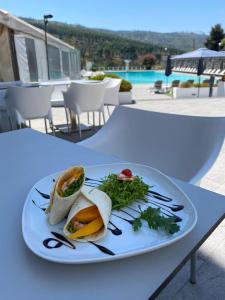 a white plate of food on a table at Grande Hotel das Caldas da Felgueira in Caldas da Felgueira