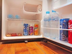 a refrigerator filled with bottles of soda and drinks at Cairo House Hostel in Cairo