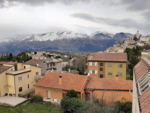 una ciudad con montañas cubiertas de nieve en el fondo en La casetta in montagna, en Torricella Peligna