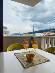 two glasses of wine on a table on a balcony at Apartments Gule in Slatine