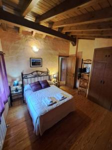 ein Schlafzimmer mit einem großen Bett in einem Zimmer in der Unterkunft Casa Rural La Pantizuela in Ortigosa de Tormes + 7 Fotos
