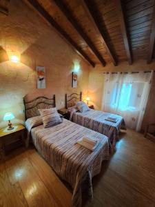 1 Schlafzimmer mit 2 Betten in einem Zimmer mit Holzböden in der Unterkunft Casa Rural La Pantizuela 