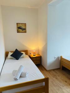 sypialnia z białym łóżkiem i drewnianą podłogą w obiekcie Apartments Gule w Slatine