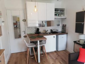 a small kitchen with a table and a counter at Studio douillet proche plage in Arcachon
