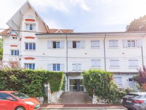 Un edificio blanco con coches aparcados delante. en Studio douillet proche plage, en Arcachon