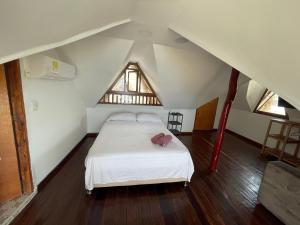 a bedroom with a white bed in a attic at Cabaña Yalis SAS in Cartagena de Indias