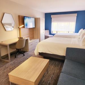 レキシントンにあるHoliday Inn Express & Suites Lexington, an IHG Hotelのベッド2台とデスクが備わるホテルルームです。