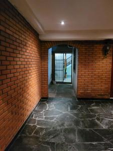 un pasillo vacío con una pared de ladrillo y una puerta en Lo De Mir en Salta