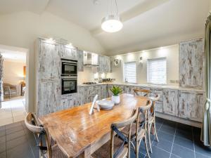 uma cozinha com uma mesa de madeira e cadeiras em Home Farm House em Sandsend