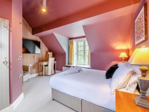 a bedroom with pink walls and a large bed at Home Farm House in Sandsend