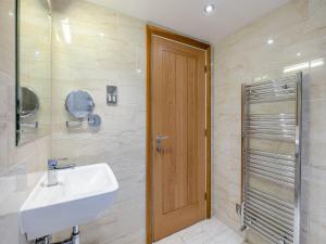 a bathroom with a sink and a wooden door at Home Farm House in Sandsend