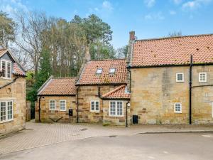 une ancienne maison en pierre avec des toits rouges et une allée. dans l'établissement Home Farm House, à Sandsend