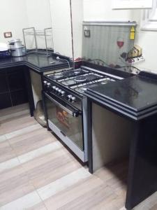 a kitchen with a stove and a counter top at Rental apartment at Ras El Bar City in ‘Izbat al Jirabī