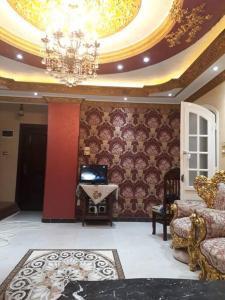 Rental apartment at Ras El Bar City في ‘Izbat al Jirabī: غرفة معيشة فيها ثريا على السقف