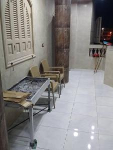 Rental apartment at Ras El Bar City في ‘Izbat al Jirabī: غرفة انتظار مع كراسي وطاولة في الغرفة