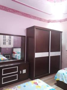 a bedroom with a large mirror and a dresser at Rental apartment at Ras El Bar City in ‘Izbat al Jirabī