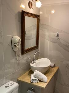 a bathroom with a sink and a mirror and a toilet at Myral Guesthouse in Nafplio