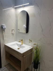 a white bathroom with a sink and a mirror at Pokoje Bakos Radocza in Radocza
