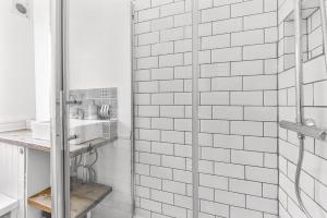 a white bathroom with a shower and a sink at Leafy Oasis Wandsworth Chic Pad in London