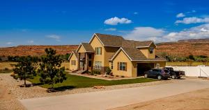 a house with a car parked in a driveway at Moab Desert Home, 4 Bedroom Private House, Sleeps 10, Pet Friendly in Moab