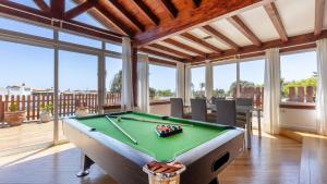 un tavolo da biliardo in un soggiorno con finestre di Luxury Villa Nieve a Caleta De Fuste