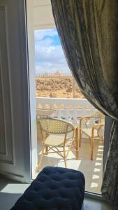 a room with a balcony with a view of the desert at Pyramids View Apartment in Giza