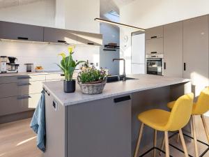 a kitchen with white cabinets and yellow bar stools at 8 person holiday home in Hirtshals-By Traum in Hirtshals