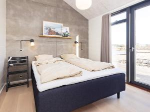 a large bed in a room with a window at 8 person holiday home in Hirtshals-By Traum in Hirtshals
