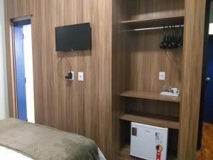 a bedroom with a bed and a tv on a wall at A3EM Casa de Gorceix in Ouro Preto