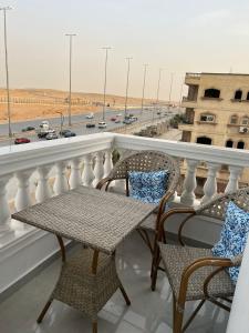a balcony with chairs and a table and a highway at Pyramids View Apartment in Giza