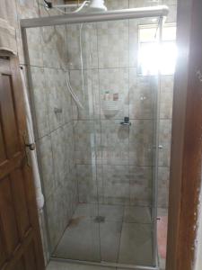 a shower with a glass door in a bathroom at Sítio Ramos casa amarela in Cunha +43 photos