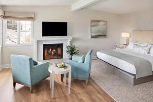 1 dormitorio con 1 cama, 2 sillas y chimenea en Green Gables Inn, A Four Sisters Inn en Pacific Grove