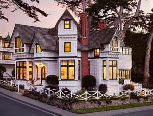 a white house with a black roof at Green Gables Inn, A Four Sisters Inn in Pacific Grove