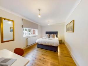 a bedroom with a bed and a desk and a table at Redhill town centre apartments by Livingo in Redhill
