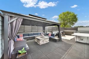 a patio with a couch and a table on a roof at City Views RoofTop Hot Tub & Short Walk to Stadium in Charlotte