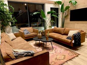 sala de estar con sofá y mesa en The Oak house - Designers private Northern lights geothermal Villa, en Mosfellsbær