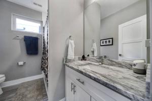 a white bathroom with a sink and a mirror at City Views RoofTop Hot Tub & Short Walk to Stadium in Charlotte +49 photos