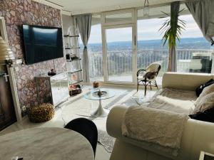 - un salon avec un canapé et une télévision dans l'établissement SUITE-XXI City View Hotelturm Augsburg, à Augsbourg