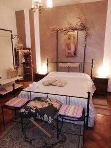 a bedroom with a bed with two chairs in it at Le Stanze di Rosa in Monsano