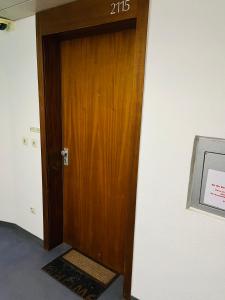 Una puerta de madera en una habitación con un cartel. en SUITE-XXI City View Hotelturm Augsburg, en Augsburg