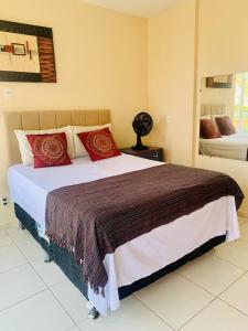 1 dormitorio con 1 cama grande con almohadas rojas en Apprainha top, en Arraial do Cabo