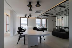 sala de estar con mesa blanca y sillas negras en Studios Novíssimos com Piscina no Rooftop e vista para o Allianz Parque en São Paulo