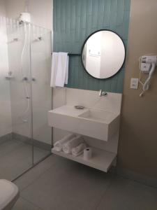 uma casa de banho com um lavatório, um chuveiro e um espelho. em A3EM Casa de Gorceix em Ouro Preto